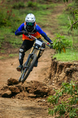 Fototapeta na wymiar A professional down hill cyclist racer jumping and doing a swipe on his full suspension carbon bike