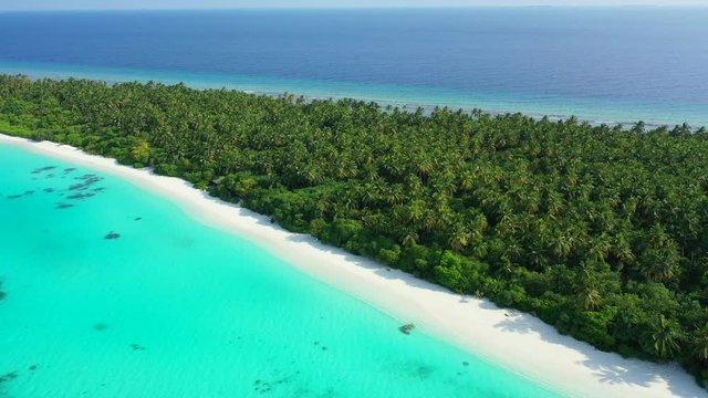 maldives above shot of narrow and long tropical islans shore with white sand beach and water around it