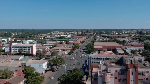 A panning left drone shot of a busy city road in Bulawayo, Zimbabwe under sunny conditions.