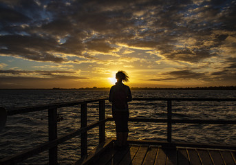 la fille en face du coucher de soleil