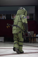 EOD officer in The explosive ordnance disposal suit take off the bomb bag with remote arm