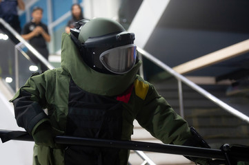 EOD officer in The explosive ordnance disposal suit searching bomb in the building room