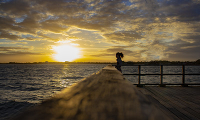 la fille en face du coucher de soleil