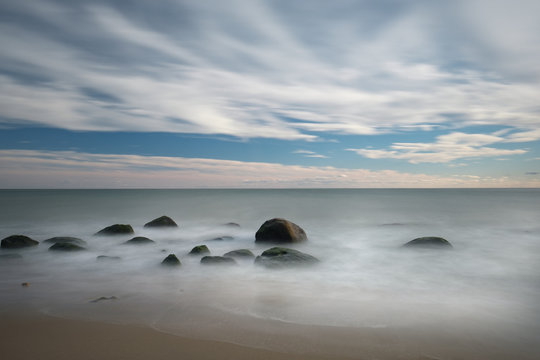 Long exposure image of large boulders on a New England Beach during the off-season