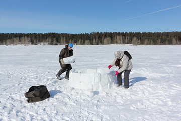 Man and woman building an igloo in a snowy glade, Novosibirsk, Russia