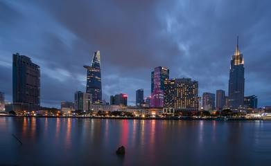 Fototapeta premium The best of night view in Ho Chi Minh City, Vietnam. Colorful of city light beside the Saigon river with skyline at sunset. Royalty high quality free stock image.