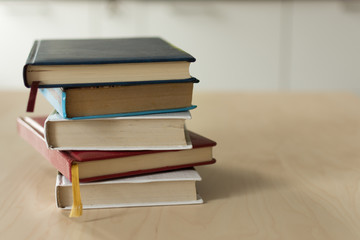 Stack of books on wooden table. Heap fo books on wooden background. Education concept.