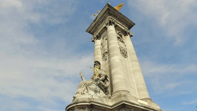 Paris and French monument sculptures hyperlapse against blue sky. Famous Pont Alexandre III columns with golden statues