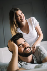 Happy young couple making massage in bedroom