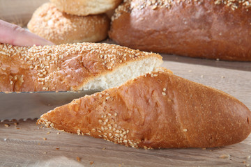 baguette cutting on the background of buns and bread