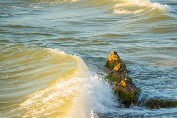 Sea big waves roll on the stones.