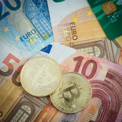 Golden bitcoins with euro notes and credit card in background, new currency, finance concept