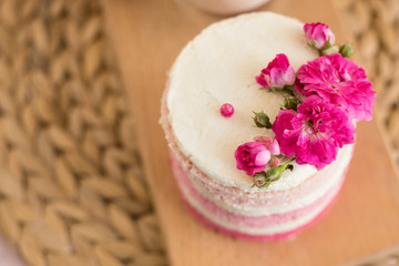 Beautiful pink cream and berries cake on a light concrete background. Birthday celebration