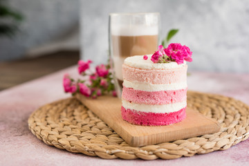 Beautiful pink cream and berries cake on a light concrete background. Birthday celebration