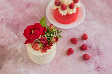 Beautiful pink cream and berries cake on a light concrete background. Birthday celebration