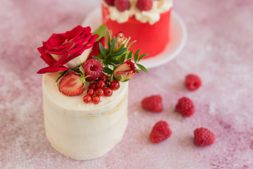 Beautiful pink cream and berries cake on a light concrete background. Birthday celebration