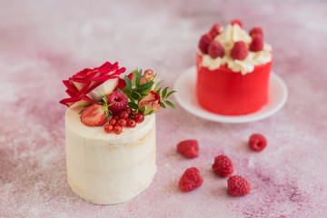 Beautiful pink cream and berries cake on a light concrete background. Birthday celebration