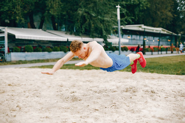Man training. Guy in a sports shorts. Male in a summer park
