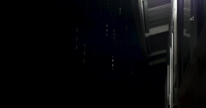 rain dripping off the roof line of a Hawaiian house in puna. the rain reflecting the white lights from the house.