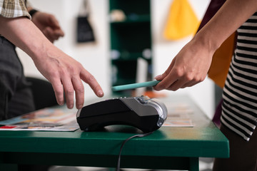 Close-up of a customer attaching smartphone to the payment terminal