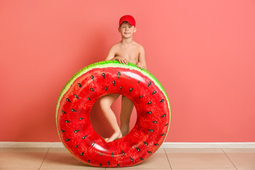 Cute little boy with inflatable ring near color wall © Pixel-Shot