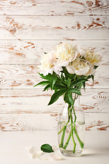Vase with beautiful peony flowers on table