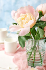 Vase with beautiful peony flowers on table
