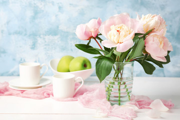 Vase with beautiful peony flowers on table