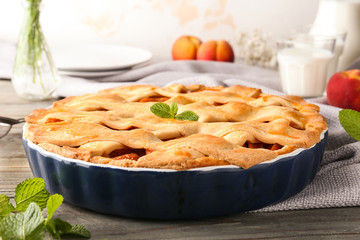 Tasty peach pie on table