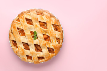 Tasty peach pie on color background