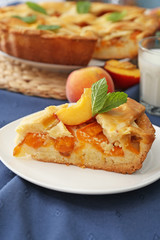 Plate with piece of tasty peach pie on table