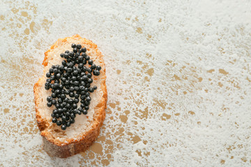 Sandwich with black caviar on light background