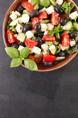 bowl of salad with feta cheese, olive, tomato and basil