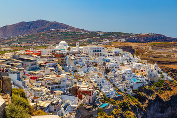 Fira town, Santorini island in Greece. Landscape with white buildings. Incredibly romantic top view of Oia village with mountai