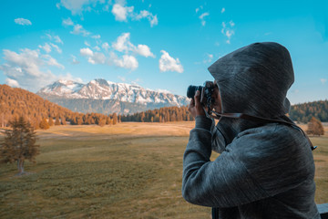 Fototapeta premium photographer taking a picture of the landscape mountains
