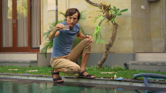 Young man swimming pool serviceman checking chlorine, PH and other chemical levels
