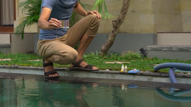 Young man swimming pool serviceman checking chlorine, PH and other chemical levels