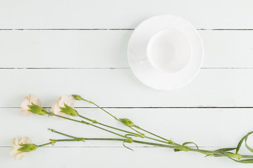 Top view flowers and cup on wooden background