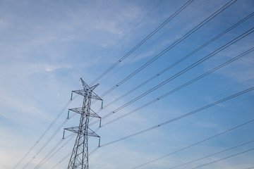 High voltage post tower with blue sky before sunset