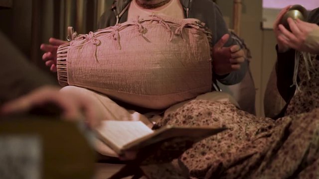 People playing different ethnic instruments: drums upholstered with pink fabric and tiny percussion cymbals, national traditions and music concept. Clip. Men playing traditional songs.