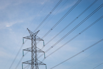 High voltage post tower with blue sky before sunset