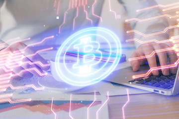 Crypto currency theme hologram with businessman working on computer on background. Concept of blockchain. Double exposure.