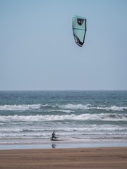 A kiteboarder on the sea at a shallow beach in Devon, UK