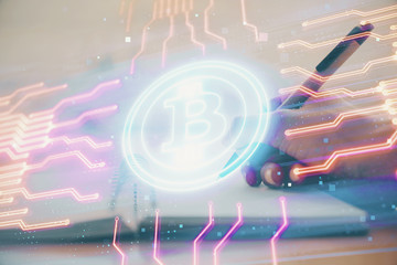 Cryptocurrency hologram over hands taking notes background. Concept of blockchain. Multi exposure