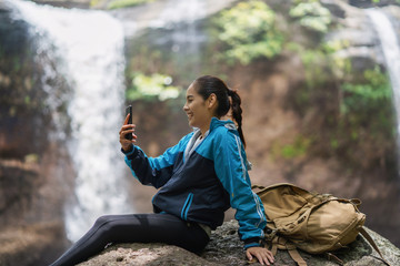 Woman tourists Is shooting a waterfall She is video call with her boyfriend.