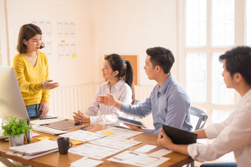 Young business group or business partners discussing documents and ideas at meeting