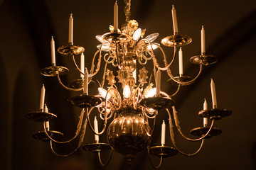 gold-plated chandelier hangs in the old church near the icons. Modern lamps are like candles.