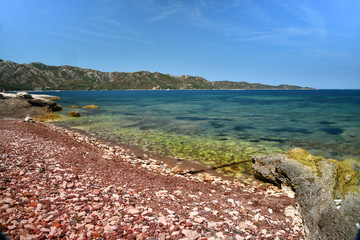 Stones, sea and blue sky in the North of Corsica during a summer vacation