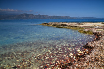 Fototapeta na wymiar Stones, sea and blue sky in the North of Corsica during a summer vacation