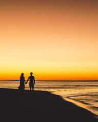 couple walking on the beach at sunset - 274216551